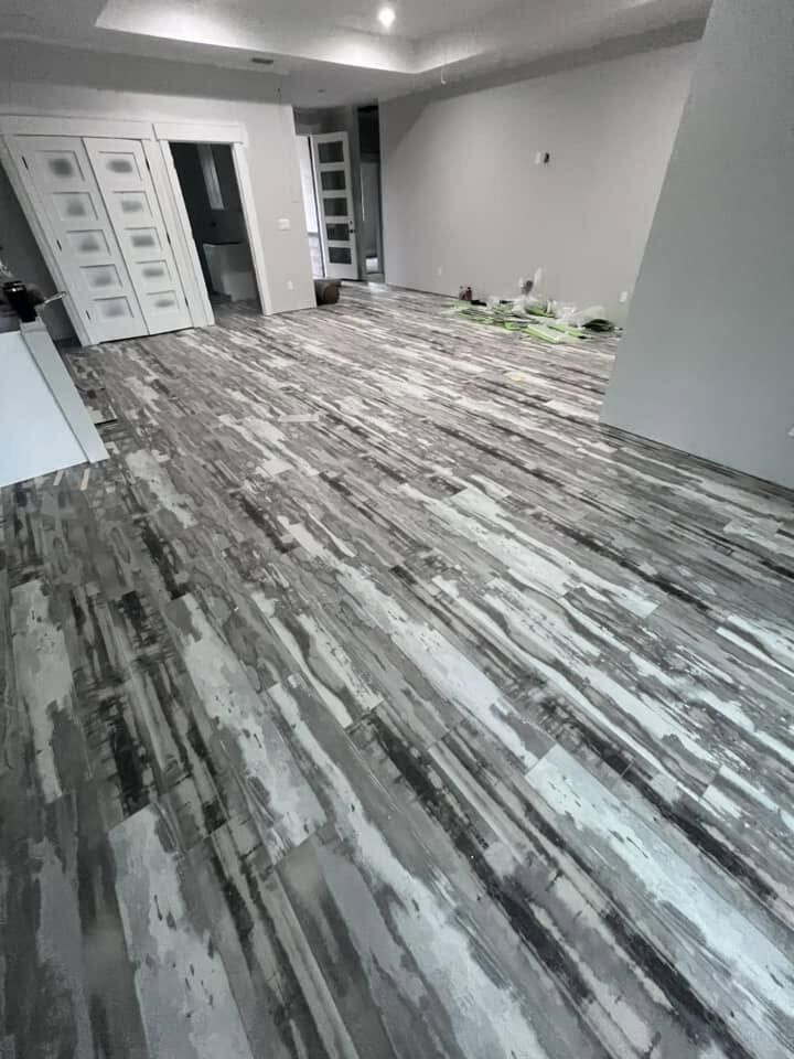 Freshly installed gray wood-look flooring in an open living area